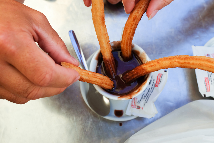 dipping churros into chocolate